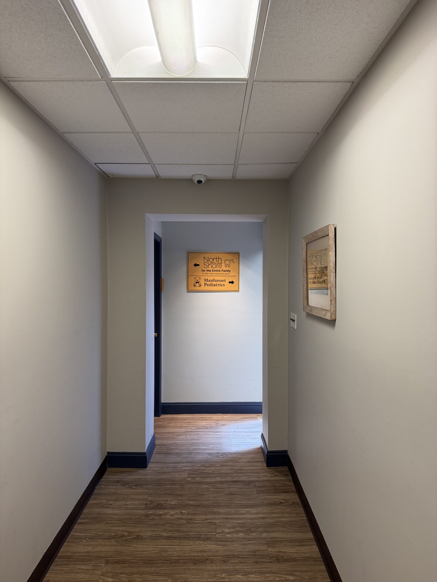 Building corridor leading to the North Shore Dental Group and Manhasset Pediatrics directional sign