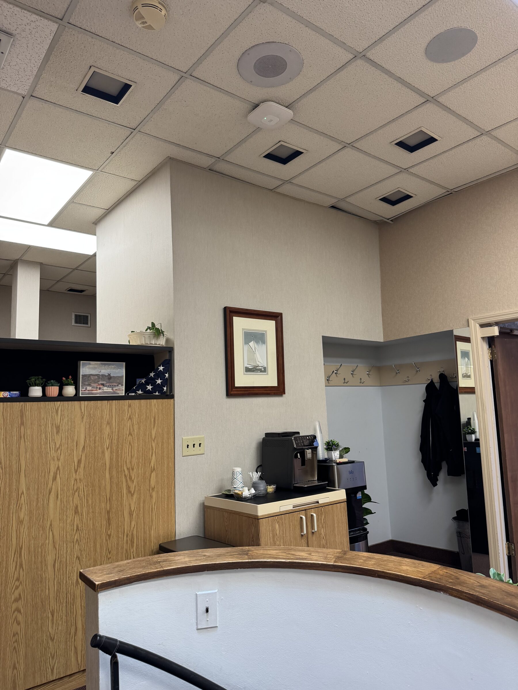 Front reception area with complimentary coffee station and coat rack at North Shore Dental Group